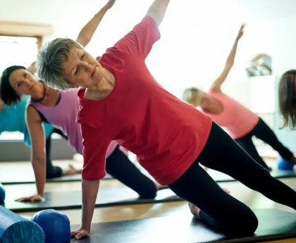 Femme pratiquant un exercice de la méthode Pilates sur un tapis à la maison