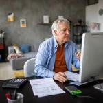 ersonne effectuant sa demande de retraite en ligne sur un ordinateur portable.