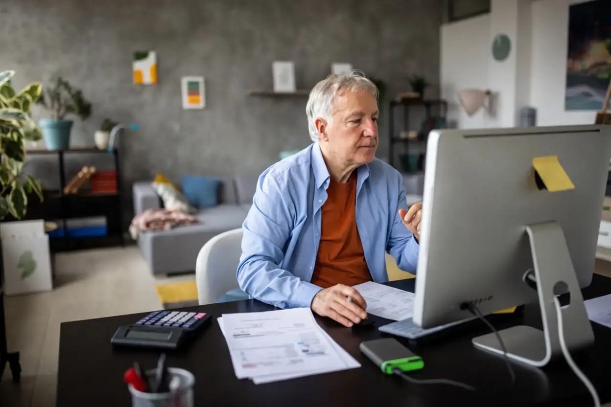 ersonne effectuant sa demande de retraite en ligne sur un ordinateur portable.