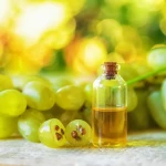 Cuillère d'huile de pépins de raisin posée sur une table avec des raisins frais