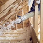 Chantier d'isolation des combles avec pose de laine de roche entre les chevrons