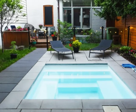 Mini piscine installée dans un jardin aménagé avec terrasse en bois