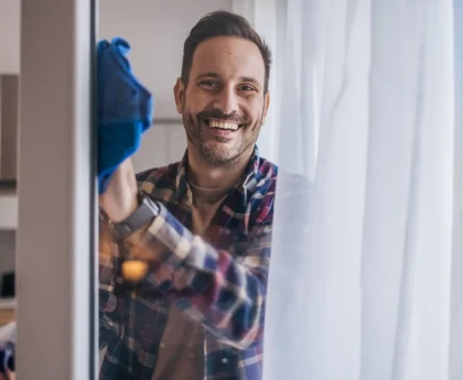 Personne nettoyant une vitre avec un chiffon et une solution d'ammoniaque