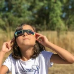 Personne portant des lunettes de protection ISO pour observer l'éclipse solaire 2026 en toute sécurité