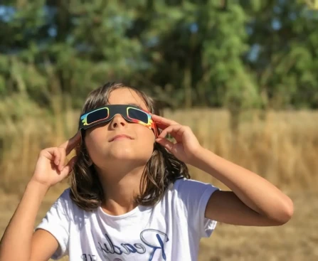 Personne portant des lunettes de protection ISO pour observer l'éclipse solaire 2026 en toute sécurité