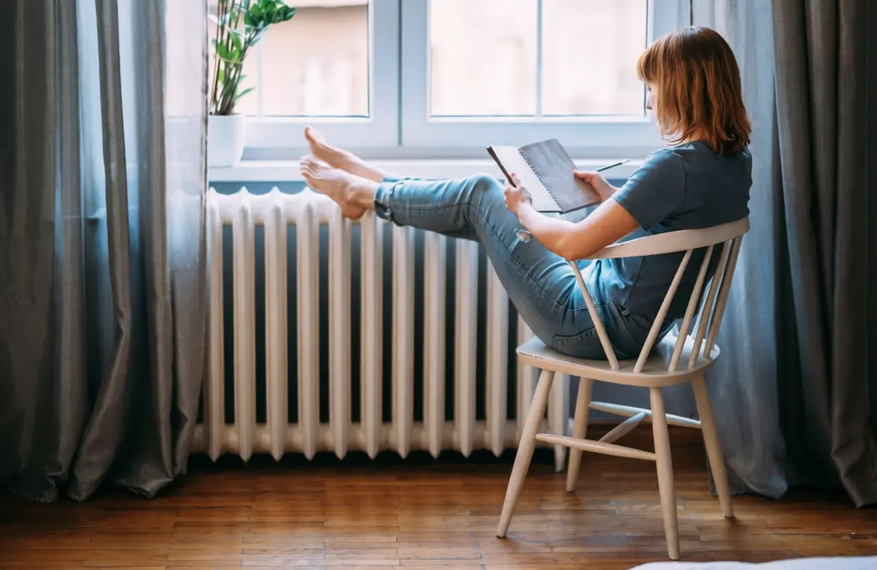 Rideau épais recouvrant un radiateur sous une fenêtre bloquant la circulation de l'air chaud