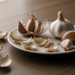 Épluchures d'ail sur une table en bois avec des gousses d'ail entières