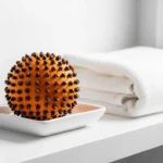 Orange piquée de clous de girofle dans une coupelle blanche, désodorisant naturel pour les toilettes